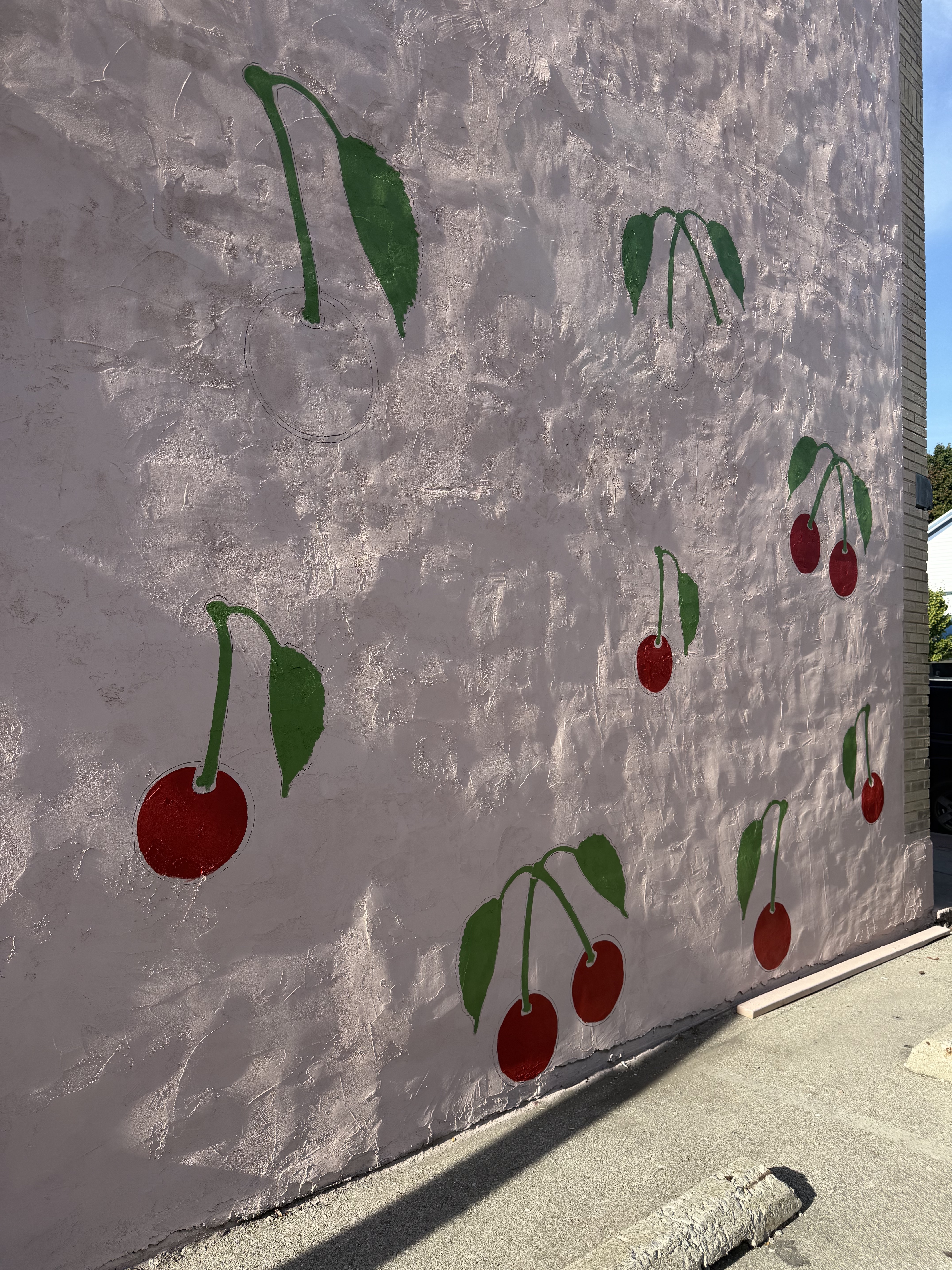 pink wall with first few cherries painted on Cherry Lanes Arcade Bar mural
